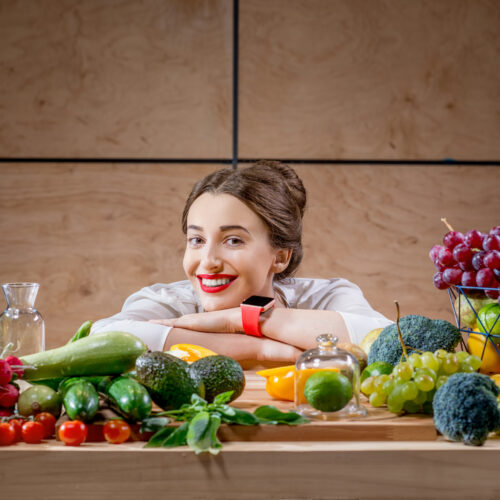 tanara cu o masa plina alimente sanatoase, legume, fructe