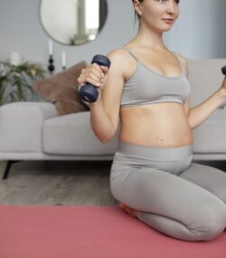 Femeie insarcinata face exercitii sport usoare pentru sarcina cu greutati mici